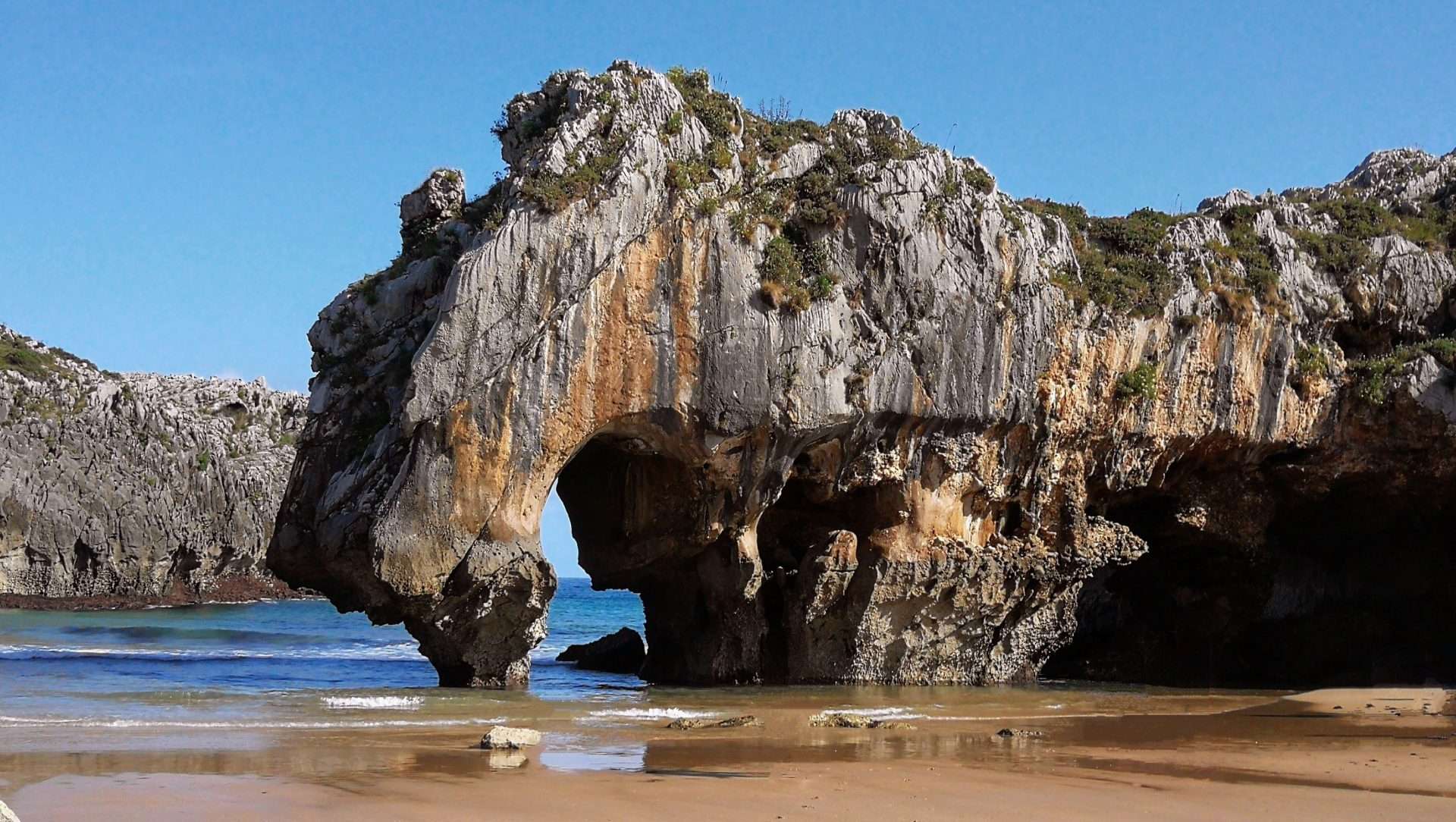 Una formación rocosa en una playa cerca del océano.